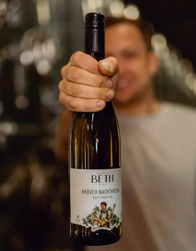 Moritz Beth mit Wein Kröver Nacktarsch in der Hand